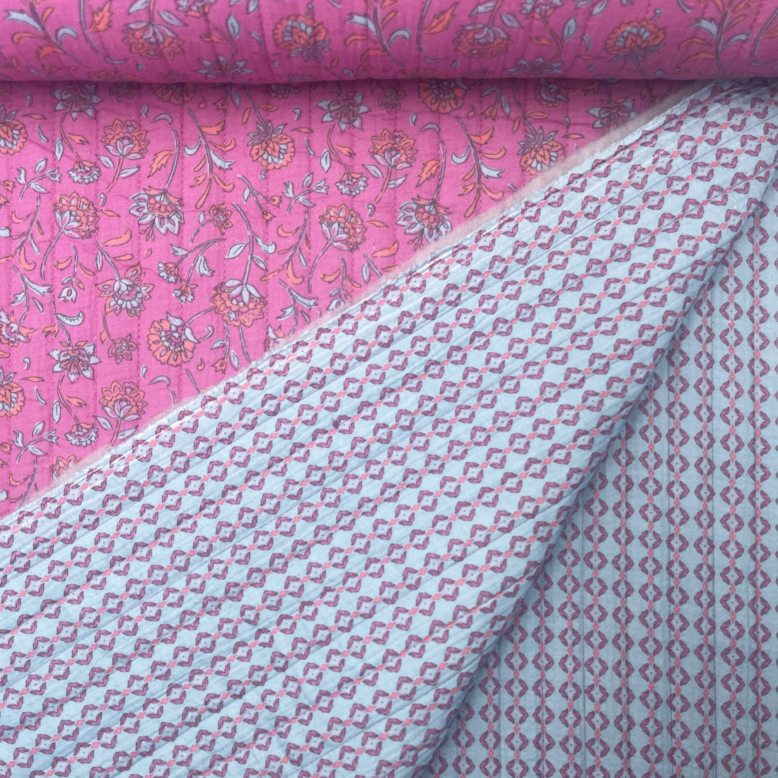 Tissu double face motif floral rouge sur fond rose