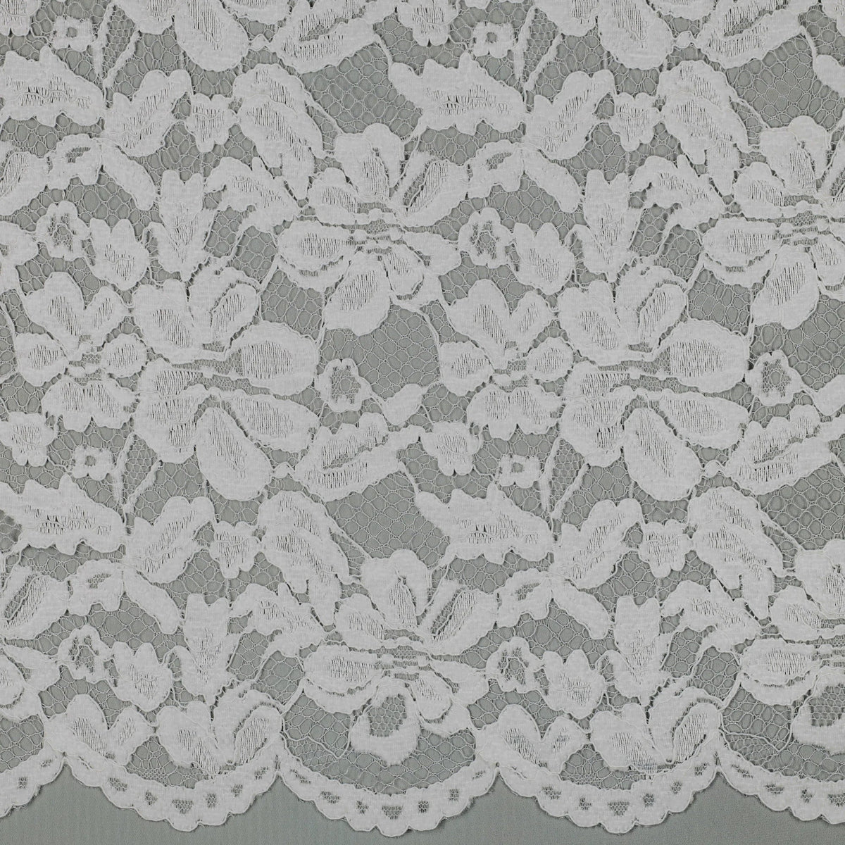Tissu dentelle blanche fleurie à bord festonné