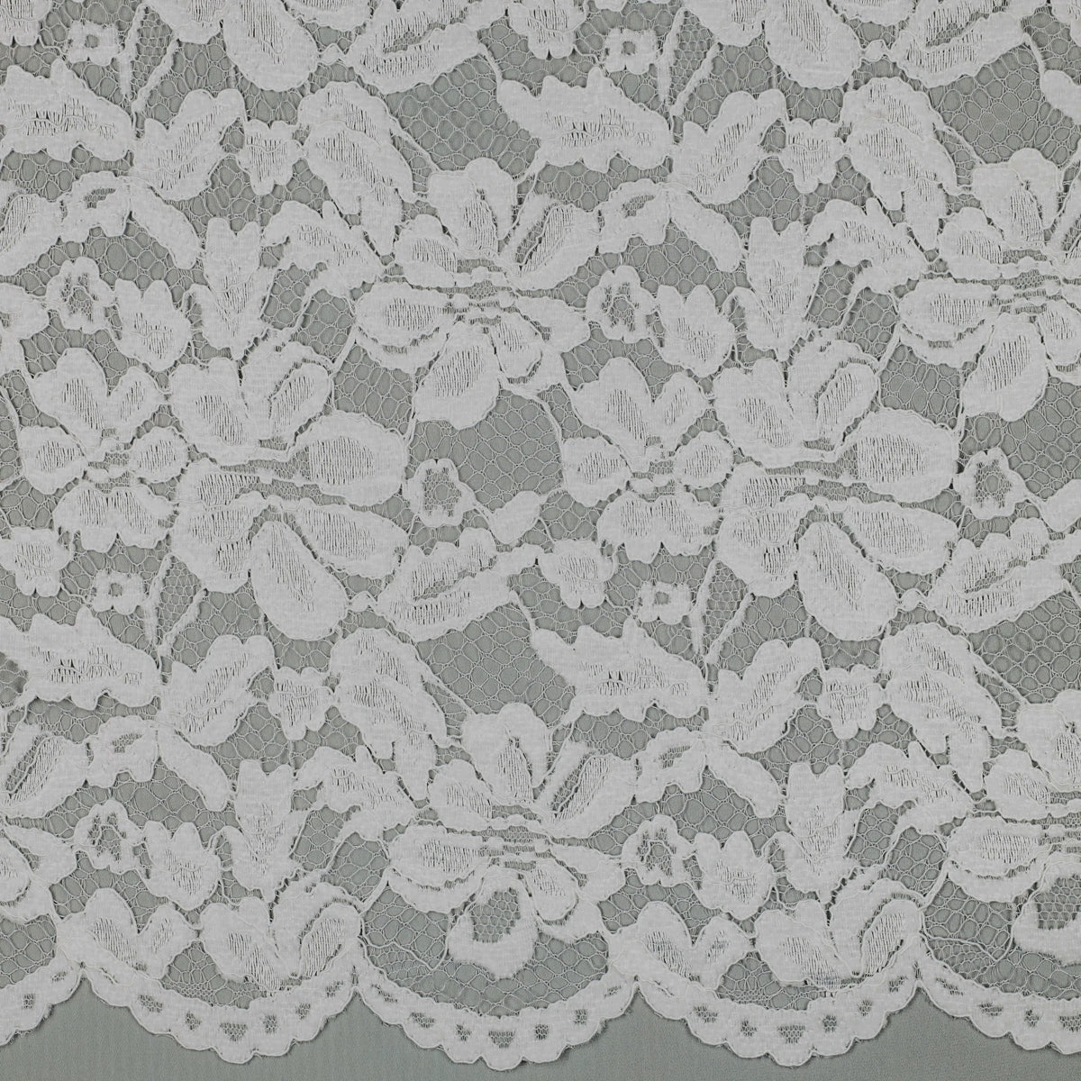 Tissu dentelle blanche fleurie à bord festonné