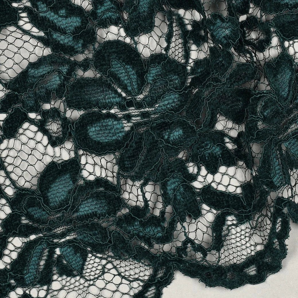 Détail des fleurs satinées de la dentelle vert émeraude