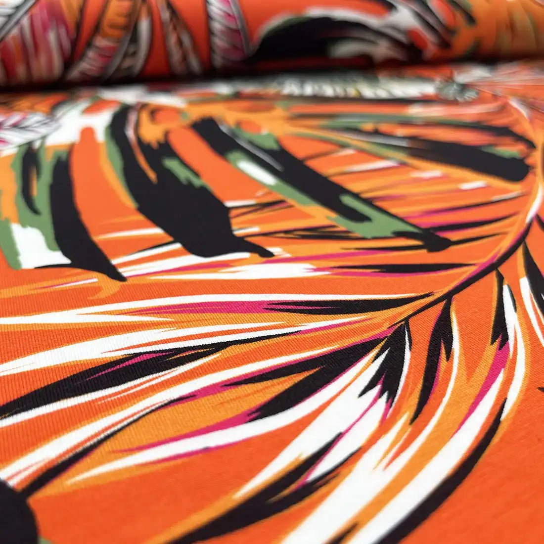Tissu Jersey tropical orange – Feuilles exotiques colorées